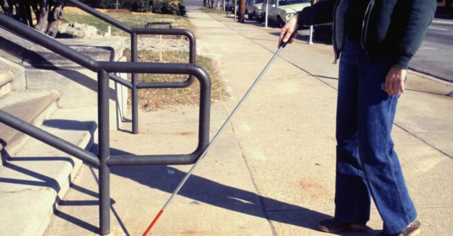 A visually impaired person using a walking stick